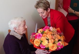 Wójt wręcza jubilatce bukiet kwiatów